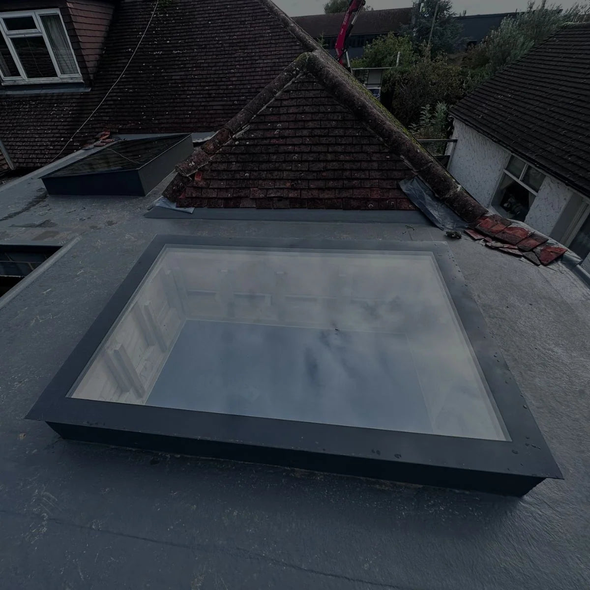 Rahmenloses Dachfenster nach Maß auf einem Flachdach, das Glas liegt auf der gedämmten Aufkantung – SkyGlas